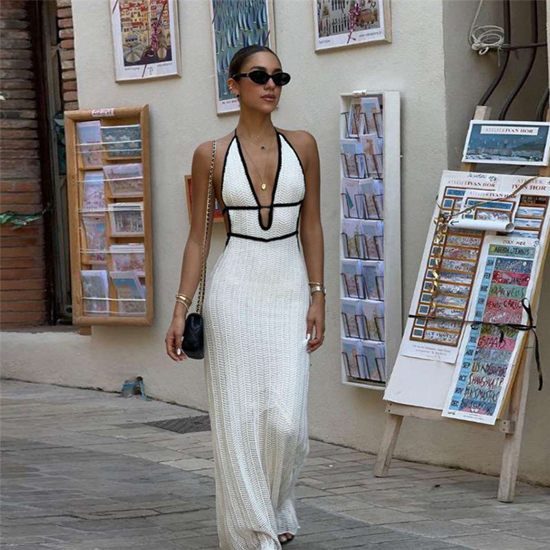 robe en tricot dos nu à col V portée par une femme, style halter, dans une rue élégante.