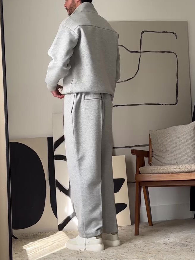 ensemble décontracté homme zip-up gris avec pantalon, vu de dos dans un environnement moderne.