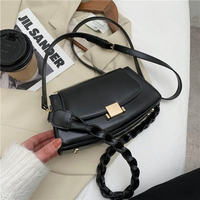 Sac à bandoulière à sangle torsadée en cuir noir avec fermeture à bouton, idéal pour le bureau et les sorties.