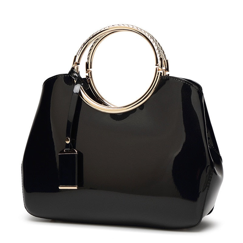 sac à main en cuir verni avec anneau en noir, design élégant et tendance pour femmes.
