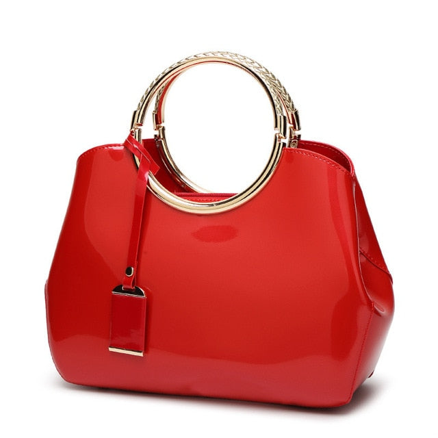 sac à main en cuir verni avec anneau couleur rouge avec poignée en métal brillant
