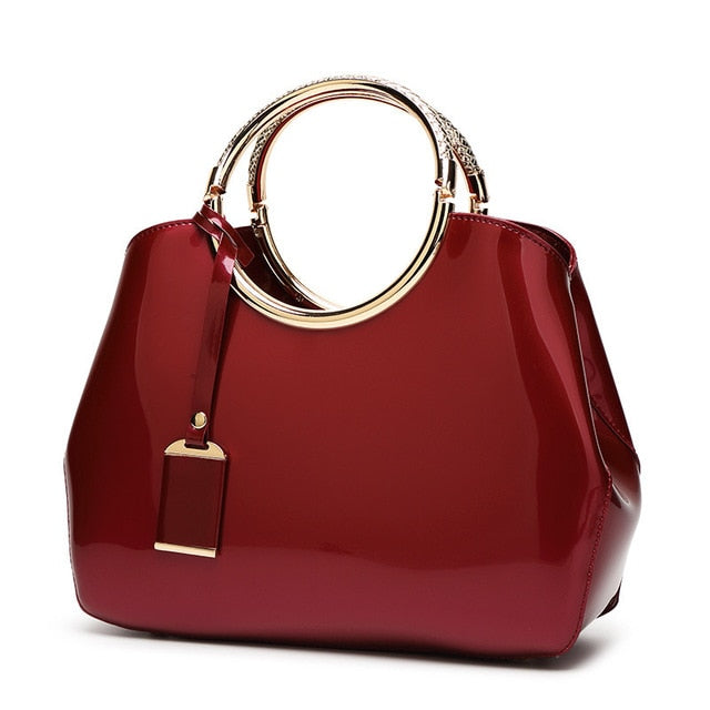 Sac à main en cuir verni avec anneau de couleur rouge, modèle élégant et tendance.