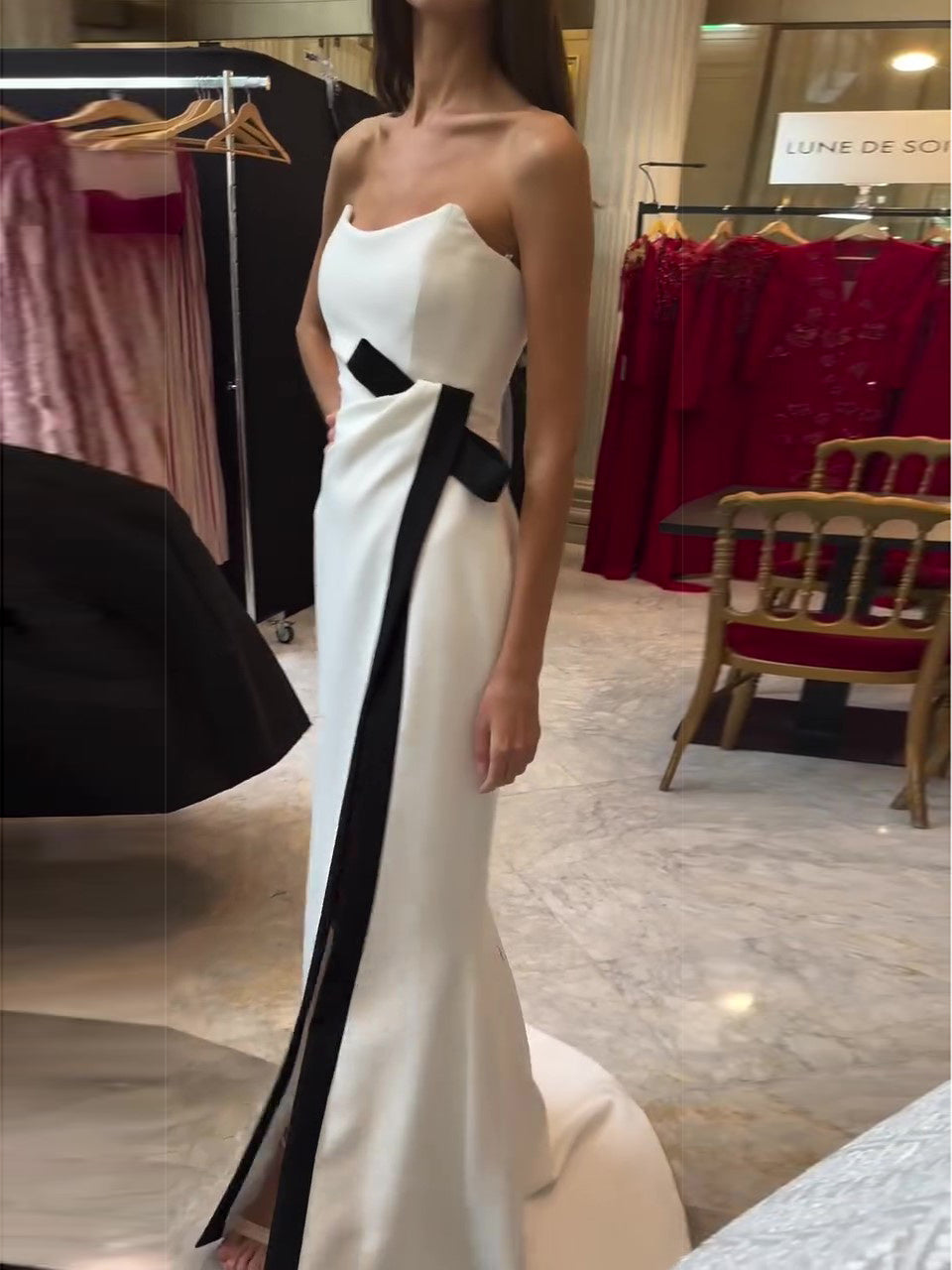 Robe maxi sans bretelles noire et blanche avec un contraste élégant et un noeud noir.