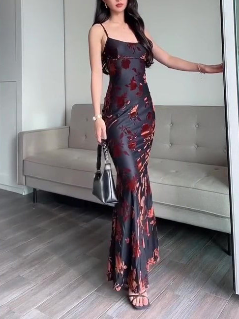 Robe maxi strappy en velours avec imprimé floral, élégante et sexy, portée par une femme devant un canapé.