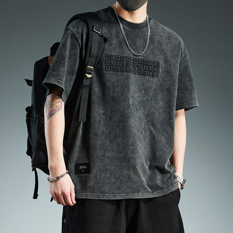 T-shirt homme décontracté polyvalent avec un design tendance et coupe ample, porté par un homme.