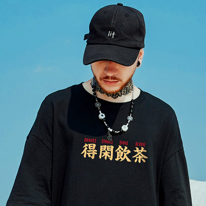 T-shirt homme été imprimé en noir, avec motif asiatique, porté par un jeune homme avec une casquette.
