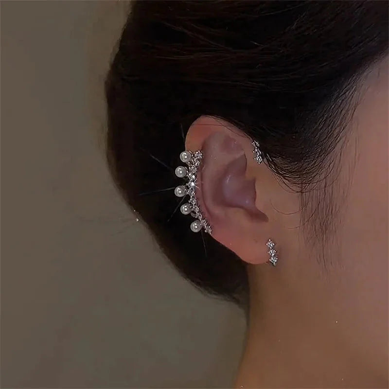 Boucle d'oreille perle argent vintage sur l'oreille d'une femme, avec des cristaux brillants et des perles élégantes.