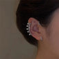 Boucle d'oreille perle argent vintage sur l'oreille d'une femme, avec des cristaux brillants et des perles élégantes.