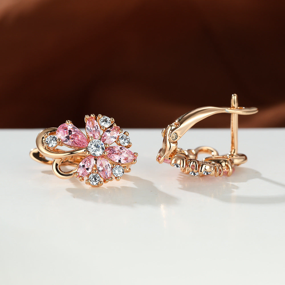 Boucles d'oreilles en zircon en forme de goutte en or rose avec des pierres précieuses roses et brillantes.