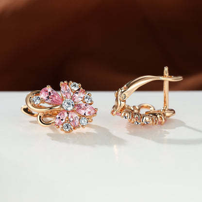 Boucles d'oreilles en zircon en forme de goutte en or rose avec des pierres précieuses roses et brillantes.